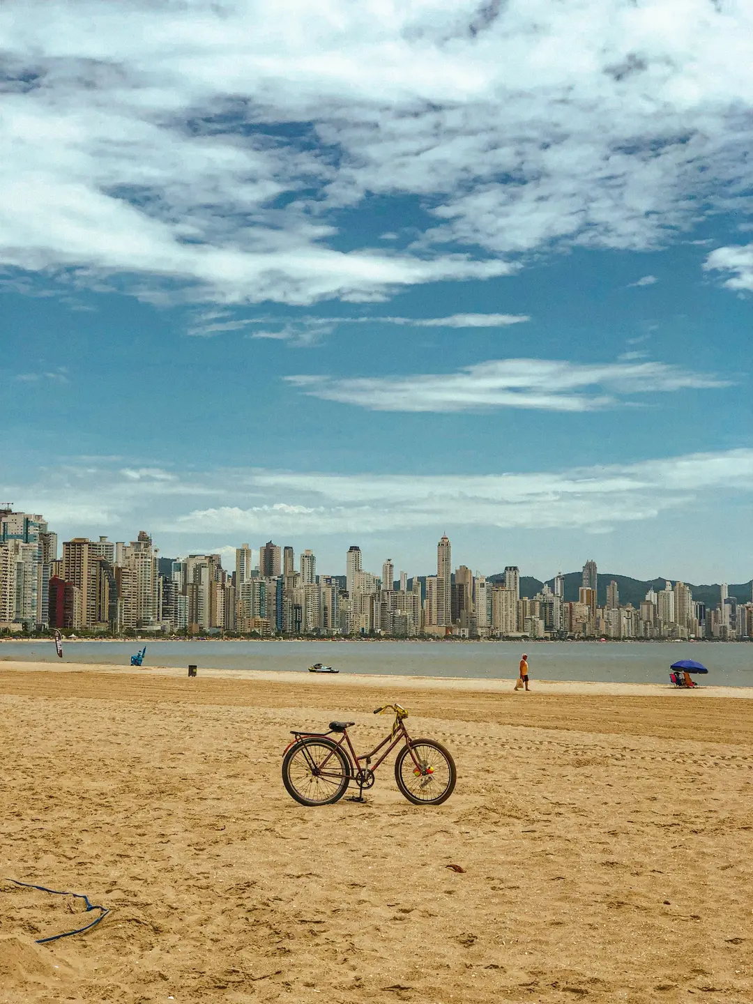 Bicicleta na areia da Praia Central de Balneário Camboriú com o skyline ao fundo